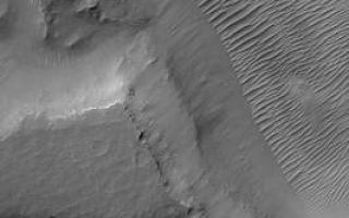 <h1>PIA06886:  Solar Conjunction Ends: Nirgal Vallis</h1><div class="PIA06886" lang="en" style="width:266px;text-align:left;margin:auto;background-color:#000;padding:10px;max-height:150px;overflow:auto;"><p>28 September 2004<br />For the past several weeks, Mars was on the other side of the Sun relative to Earth. During this period, known as solar conjunction, radio communication with spacecraft orbiting and roving on Mars was limited. As is always done during solar conjunction, on 7 September 2004, the Mars Global Surveyor (MGS) Mars Orbiter Camera (MOC) was turned off. On Saturday, 25 September 2004, the MOC team gathered at Malin Space Science Systems to command the instrument to turn back on again. After a successful turn-on, MOC acquired its first narrow angle camera image, shown here, on orbit 24808 (24,808th orbit since the start of the Mapping phase of the MGS mission in March 1999). </p><p>The 25 September image shows a portion of Nirgal Vallis, an ancient valley system in the Mare Erythraeum region of Mars. The valley floor is covered by large, ripple-like bedforms created by wind. This early southern winter image is located near 27.4°S, 42.9°W, and covers an area approximately 3 km (1.9 mi) across. Sunlight illuminates the scene from the upper left. </p><p>This was the 4th solar conjunction period that MGS and MOC have been through since the spacecraft reached the red planet in September 1997. The four solar conjunction periods, where MOC was turned off, were: <p> First solar conjunction: 29 April - 1 June 1998 Second solar conjunction: 22 June - 12 July 2000 Third solar conjunction: 1 August - 18 August 2002 Fourth solar conjunction: 7 September - 25 September 2004.</p><p>In late October, MGS MOC will mark the start of its fourth Mars year since the beginning of the Mapping Phase of the mission in March 1999. MGS and MOC have already been orbiting Mars for more than 4 Mars years, including the pre-Mapping aerobrake and science phasing orbit insertion periods. </p><br /><br /><a href="http://photojournal.jpl.nasa.gov/catalog/PIA06886" onclick="window.open(this.href); return false;" title="Voir l'image 	 PIA06886:  Solar Conjunction Ends: Nirgal Vallis	  sur le site de la NASA">Voir l'image 	 PIA06886:  Solar Conjunction Ends: Nirgal Vallis	  sur le site de la NASA.</a></div>