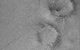 <h1>PIA06898:  Boulder Rings</h1><div class="PIA06898" lang="en" style="width:800px;text-align:left;margin:auto;background-color:#000;padding:10px;max-height:150px;overflow:auto;"><p>2 October 2004<br />This Mars Global Surveyor (MGS) Mars Orbiter Camera (MOC) image shows raised-rimmed, circular features sometimes described as "boulder rings." These are located on the vast martian northern plains, and they are, basically, somewhat filled and somewhat buried meteor impact craters. The small, dark dots on these rings are boulders derived from the craters' ejecta and perhaps from erosion of the rock in which the craters formed. This image is located near 70.4°N, 310.4°W, and covers an area about 3 km (1.9 mi) across. Sunlight illuminates the scene from the lower left.</p><br /><br /><a href="http://photojournal.jpl.nasa.gov/catalog/PIA06898" onclick="window.open(this.href); return false;" title="Voir l'image 	 PIA06898:  Boulder Rings	  sur le site de la NASA">Voir l'image 	 PIA06898:  Boulder Rings	  sur le site de la NASA.</a></div>