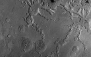 <h1>PIA06956:  Fretted Terrain</h1><div class="PIA06956" lang="en" style="width:593px;text-align:left;margin:auto;background-color:#000;padding:10px;max-height:150px;overflow:auto;"><p>20 October 2004<br >This red wide angle Mars Global Surveyor (MGS) Mars Orbiter Camera (MOC) image shows a portion of the fretted terrain north of eastern Arabia Terra. As described earlier this month in "<a href="/catalog/PIA06900">Craters in Fretted Terrain</a>," the fretted terrains of Mars are the broken-up, blocky areas where the heavily cratered martian highlands transition to the lightly-cratered, lower elevation, northern plains. The landforms in the top half of the picture shown here comprise a portion of the fretted terrain. This picture has a resolution of about 243 meters (266 yards) per pixel and covers an area about 248 kilometers (154 miles) wide. The long valley that runs diagonal from lower center toward right center in the bottom half of the picture is Auqakuh Vallis. This image is located near 32°N, 299°W, and is illuminated by sunlight from the left/lower left. Another view of landforms in the fretted terrain was featured yesterday in "<a href="/catalog/PIA06950">Fretted Terrain Craters</a>."</p><br /><br /><a href="http://photojournal.jpl.nasa.gov/catalog/PIA06956" onclick="window.open(this.href); return false;" title="Voir l'image 	 PIA06956:  Fretted Terrain	  sur le site de la NASA">Voir l'image 	 PIA06956:  Fretted Terrain	  sur le site de la NASA.</a></div>