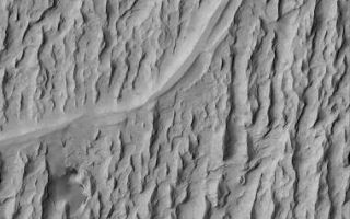 <h1>PIA07057:  Inverted Channels of Aeolis</h1><div class="PIA07057" lang="en" style="width:380px;text-align:left;margin:auto;background-color:#000;padding:10px;max-height:150px;overflow:auto;"><p>17 November 2004<br >Mars was once a much wetter world than it is today. Locked within the martian bedrock are ancient channels and valleys through which liquids -- e.g., water -- once flowed. In the Aeolis region of Mars, wind erosion has exposed and inverted a plethora of ancient channels - stream beds -- in a fan-shaped sedimentary rock unit near 6.3°S, 208.6°W. This Mars Global Surveyor (MGS) Mars Orbiter Camera (MOC) image shows an example. The smooth-looking, sinuous ridges that run left-right across the image are the inverted channels. The rugged, sharp-looking ridges that run nearly north-south (up-down) through the image are yardangs--ridges formed by wind erosion. The water (or other liquid) responsible for the original channels flowed from the left (west) to right/upper right (east/northeast). This scene covers an area approximately 3 km (1.9 mi) across, and is illuminated by sunlight from the upper left.</p><br /><br /><a href="http://photojournal.jpl.nasa.gov/catalog/PIA07057" onclick="window.open(this.href); return false;" title="Voir l'image 	 PIA07057:  Inverted Channels of Aeolis	  sur le site de la NASA">Voir l'image 	 PIA07057:  Inverted Channels of Aeolis	  sur le site de la NASA.</a></div>