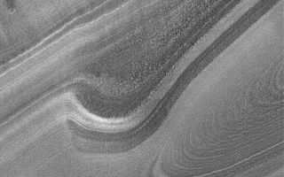 <h1>PIA07118:  North Polar Layers</h1><div class="PIA07118" lang="en" style="width:672px;text-align:left;margin:auto;background-color:#000;padding:10px;max-height:150px;overflow:auto;"><p>3 December 2004<br >This Mars Global Surveyor (MGS) Mars Orbiter Camera (MOC) image shows an exposure of finely-detailed layers in the martian north polar region. The polar ice cap, which is made up of frozen water (whereas the south polar cap is mostly frozen carbon dioxide), is underlain by a thick sequence of layers. Some have speculated that these layers may record the history of changes in martian climate during the past few hundreds of millions of years. This picture is located near 86.0°N, 30.2°W, and covers an area approximately 3 km (1.9 mi) across. Sunlight illuminates the scene from the lower left.</p><br /><br /><a href="http://photojournal.jpl.nasa.gov/catalog/PIA07118" onclick="window.open(this.href); return false;" title="Voir l'image 	 PIA07118:  North Polar Layers	  sur le site de la NASA">Voir l'image 	 PIA07118:  North Polar Layers	  sur le site de la NASA.</a></div>