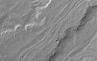 <h1>PIA07129:  Leveed Channel in Lava Flow</h1><div class="PIA07129" lang="en" style="width:512px;text-align:left;margin:auto;background-color:#000;padding:10px;max-height:150px;overflow:auto;"><p>14 December 2004<br >This Mars Global Surveyor (MGS) Mars Orbiter Camera (MOC) image shows a leveed channel running down the middle of a lava flow in Daedalia Planum, the southern plains of the Tharsis volcanic region. Transport of fluid lava through a channel such as this helps insulate the molten rock, keeping it hot longer, and thus permits the flow to extend to greater distances than it otherwise might. This example is located near 23.6°S, 123.2°W, and covers an area approximately 3 km (1.9 mi) wide. The scene is illuminated by sunlight from the upper left.</p><br /><br /><a href="http://photojournal.jpl.nasa.gov/catalog/PIA07129" onclick="window.open(this.href); return false;" title="Voir l'image 	 PIA07129:  Leveed Channel in Lava Flow	  sur le site de la NASA">Voir l'image 	 PIA07129:  Leveed Channel in Lava Flow	  sur le site de la NASA.</a></div>
