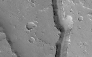 <h1>PIA07133:  Trough Near Stygis Catena</h1><div class="PIA07133" lang="en" style="width:800px;text-align:left;margin:auto;background-color:#000;padding:10px;max-height:150px;overflow:auto;"><p>18 December 2004<br >This Mars Global Surveyor (MGS) Mars Orbiter Camera (MOC) image shows a trough in the Stygis Catena region east of the martian volcano, Elysium Mons. The trough probably formed by collapse. Large, dark boulders can be seen on the trough floor in this volcanic region. The image is located near 24.4°N, 210.4°W. The image covers an area about 3 km (1.9 mi) wide and sunlight illuminates the scene from the lower left.</p><br /><br /><a href="http://photojournal.jpl.nasa.gov/catalog/PIA07133" onclick="window.open(this.href); return false;" title="Voir l'image 	 PIA07133:  Trough Near Stygis Catena	  sur le site de la NASA">Voir l'image 	 PIA07133:  Trough Near Stygis Catena	  sur le site de la NASA.</a></div>