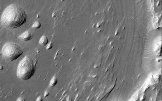 <h1>PIA07184:  Layers and Exhuming Crater</h1><div class="PIA07184" lang="en" style="width:512px;text-align:left;margin:auto;background-color:#000;padding:10px;max-height:150px;overflow:auto;"><p>30 December 2004<br >This Mars Global Surveyor (MGS) Mars Orbiter Camera (MOC) image shows a portion of an old impact crater that was filled, buried, and is now being exhumed from within sedimentary rock strata located in western Arabia Terra, the region immediately north of Meridiani Planum. The Mars Exploration Rover, Opportunity, has explored sedimentary rocks in the Meridiani region; the rocks of nearby western Arabia can only be explored (for the time being) from orbit. Wind has sculpted some of the layered rock into streamlined forms known as yardangs. The crater shown here, at one time, may have been the site of a small lake. The crater is located near 8.4°N, 5.7°W. The picture covers an area about 3 km (1.9 mi) across and is illuminated by sunlight from the upper left.</p><br /><br /><a href="http://photojournal.jpl.nasa.gov/catalog/PIA07184" onclick="window.open(this.href); return false;" title="Voir l'image 	 PIA07184:  Layers and Exhuming Crater	  sur le site de la NASA">Voir l'image 	 PIA07184:  Layers and Exhuming Crater	  sur le site de la NASA.</a></div>