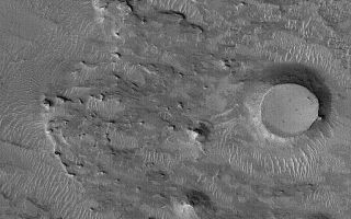 <h1>PIA07215:  West of Meridiani</h1><div class="PIA07215" lang="en" style="width:512px;text-align:left;margin:auto;background-color:#000;padding:10px;max-height:150px;overflow:auto;"><p>7 January 2004<br >This Mars Global Surveyor (MGS) Mars Orbiter Camera (MOC) image shows an eroded landscape occurring west of Sinus Meridiani, the region in which the Mars Exploration Rover, Opportunity, landed nearly a year ago. The bedrock at this location is buried beneath a mantle of dust, sand, and granules, but remnants of younger layers of bedrock now stand high in the form of buttes in the lower right quarter of the image. The two circular mesas were once meteor impact craters. They were filled, buried, and fossilized within the rock, then later exhumed. This scene is located near 1.5°N, 6.2°W. The picture covers an area about 3 km (1.9 mi) across, and is illuminated by sunlight from the lower left.</p><br /><br /><a href="http://photojournal.jpl.nasa.gov/catalog/PIA07215" onclick="window.open(this.href); return false;" title="Voir l'image 	 PIA07215:  West of Meridiani	  sur le site de la NASA">Voir l'image 	 PIA07215:  West of Meridiani	  sur le site de la NASA.</a></div>