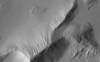 <h1>PIA07271:  Layers in Sulci Gordii</h1><div class="PIA07271" lang="en" style="width:640px;text-align:left;margin:auto;background-color:#000;padding:10px;max-height:150px;overflow:auto;"><p>9 January 2004<br >This Mars Global Surveyor (MGS) Mars Orbiter Camera (MOC) image shows detailed layered rock features, mantled by fine dust, in the Sulci Gordii ridged region east of Olympus Mons. The scene is located near 21.9°N, 124.3°W. The picture covers an area about 3 km (1.9 mi) across, and is illuminated by sunlight from the left.</p><br /><br /><a href="http://photojournal.jpl.nasa.gov/catalog/PIA07271" onclick="window.open(this.href); return false;" title="Voir l'image 	 PIA07271:  Layers in Sulci Gordii	  sur le site de la NASA">Voir l'image 	 PIA07271:  Layers in Sulci Gordii	  sur le site de la NASA.</a></div>