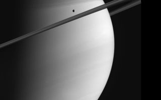 <h1>PIA07560:  Saturn and Tethys</h1><div class="PIA07560" lang="en" style="width:800px;text-align:left;margin:auto;background-color:#000;padding:10px;max-height:150px;overflow:auto;"><p>Saturn poses with Tethys in this Cassini view.  The C ring casts thin, string-like shadows on the northern hemisphere. Above that lurks the shadow of the much denser B ring. Cloud bands in the atmosphere are subtly visible in the south.  Tethys is 1,071 kilometers (665 miles) across.</p><p>Cassini will perform a close flyby of Tethys on September 24, 2005.</p><p>The image was taken on June 10, 2005, in visible green light with the Cassini spacecraft wide-angle camera at a distance of approximately 1.4 million kilometers (900,000 miles) from Saturn. The image scale is 81 kilometers (50 miles) per pixel.</p><p>The Cassini-Huygens mission is a cooperative project of NASA, the European Space Agency and the Italian Space Agency.  The Jet Propulsion Laboratory, a division of the California Institute of Technology in Pasadena, manages the mission for NASA's Science Mission Directorate, Washington, D.C. The Cassini orbiter and its two onboard cameras were designed, developed and assembled at JPL.  The imaging operations center is based at the Space Science Institute in Boulder, Colo.</p><p>For more information about the Cassini-Huygens mission visit http://saturn.jpl.nasa.gov . The Cassini imaging team homepage is at http://ciclops.org .</p><br /><br /><a href="http://photojournal.jpl.nasa.gov/catalog/PIA07560" onclick="window.open(this.href); return false;" title="Voir l'image 	 PIA07560:  Saturn and Tethys	  sur le site de la NASA">Voir l'image 	 PIA07560:  Saturn and Tethys	  sur le site de la NASA.</a></div>