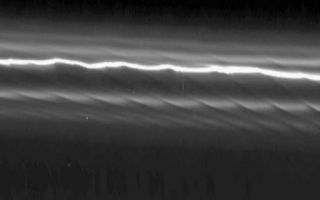 <h1>PIA07750:  The Prometheus Effect</h1><div class="PIA07750" lang="en" style="width:800px;text-align:left;margin:auto;background-color:#000;padding:10px;max-height:150px;overflow:auto;"><p>This mosaic of 15 Cassini images of Saturn's F ring shows how the moon Prometheus creates a gore in the ring once every 14.7 hours, as it approaches and recedes from the F ring on its eccentric orbit.</p><p>The individual images have been processed to make the ring appear as if it has been straightened, making it easier to see the ring's structure. The mosaic shows a region 147,000 kilometers (91,000 miles) along the ring (horizontal direction in the image); this represents about 60 degrees of longitude around the ring. The region seen here is about 1,500 kilometers (900 miles) across (vertical direction). The first and last images in the mosaic were taken approximately 2.5 hours apart.</p><p>Each dark channel, or "gore," is clearly visible across more than 1,000 kilometers (600 miles) of the ring and is due to the gravitational effect of Prometheus (102 kilometers, or 63 miles across), even though the moon does not enter the F ring. The channels have different tilts because the ring particles closer to Prometheus (overexposed, stretched, and just visible at the bottom right of the image) move slower with respect to the moon than those farther away. This causes the channels to shear with time, their slopes becoming greater, and gives the overall visual impression of drapes of ring material. The channels at the right are the youngest and have near-vertical slopes, while those at the left are the oldest and have near-horizontal slopes. </p><p>This phenomenon has not previously been detected in any other planetary ring system, but computer simulations of the system prove that the disturbance is caused by a simple gravitational interaction. The eccentric orbit of Prometheus is gradually moving so that the moon will eventually come even closer in its closest approach to the eccentric F ring. Scientists calculate that its perturbations of the F ring will reach a maximum in December 2009.</p><p>The images in this mosaic were taken using the Cassini spacecraft narrow-angle camera on April 13, 2005, at a distance of approximately 1.1 million kilometers (700,000 miles) from Saturn. The resolution in the original images, before reprojection, was 6 kilometers (4 miles) per pixel.</p><p>The Cassini-Huygens mission is a cooperative project of NASA, the European Space Agency and the Italian Space Agency. The Jet Propulsion Laboratory, a division of the California Institute of Technology in Pasadena, manages the mission for NASA's Science Mission Directorate, Washington, D.C. The Cassini orbiter and its two onboard cameras were designed, developed and assembled at JPL. The imaging operations center is based at the Space Science Institute in Boulder, Colo.</p><p>For more information about the Cassini-Huygens mission visit <a href="http://saturn.jpl.nasa.gov">http://saturn.jpl.nasa.gov</a>. The Cassini imaging team homepage is at <a href="http://ciclops.org">http://ciclops.org</a>.</p><br /><br /><a href="http://photojournal.jpl.nasa.gov/catalog/PIA07750" onclick="window.open(this.href); return false;" title="Voir l'image 	 PIA07750:  The Prometheus Effect	  sur le site de la NASA">Voir l'image 	 PIA07750:  The Prometheus Effect	  sur le site de la NASA.</a></div>