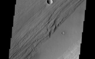 <h1>PIA07846:  Kasei Vallis Topography</h1><div class="PIA07846" lang="en" style="width:550px;text-align:left;margin:auto;background-color:#000;padding:10px;max-height:150px;overflow:auto;"><a href="/figures/PIA07846_fig1.jpg"></a><br /><p>Kasei Vallis is our topic for the weeks of April 18 and 25. Originating on the margin of Lunae Planum, the Kasei Vallis complex contains two main channels that run east-west across Tempe Terra and empty into Chryse Planitia. During the week of April 18th we will concentrate on the northern branch of Kasei Vallis. The week of April 25 will be devoted to the southern branch.</p><p>The formation of Kasei Vallis is still being studied and several theories exist. It is thought that volcanic subsurfaceing heating in the Tharsis/Lunae Planum region resulted in a release of water, which carved the channels and produced the landforms seen within the channels. One theory is that this was a one-time catastropic event, another theory speculates that several flooding events occurred over a long time period. Others have proposed that some of the landforms (especially scour marks and teardropshaped "islands") are the result of glacial flow rather than liquid flow. Teardrop shaped islands are common in terrestrial rivers, where the water is eroding material in the channel. A glacial feature called a <a href="http://www.zephryus.demon.co.uk/geography/resources/glaciers/drum.html">drumlin</a> has the exact sameshape, but is formed by deposition beneath continental glaciers.</p><p>This VIS image illustrates the complex topography within Kasei Vallis. The smoother appearing section is the lowest in elevation and has been filled by deposition. To either side are eroded banks. The parallel striations running from lower-left to upper-right can represent: rock layers eroded to show the layering, terracing -- erosion of the rock by different depths of flow, or scouring caused by material being ground against the banks by the downstream flow. Terracing is usually associated with action by liquid water; scour is generally associated with glacial (ice) flow. </p><p>Image information: VIS instrument. Latitude 26.7, Longitude 290.7 East (69.3 West). 19 meter/pixel resolution.</p><p>Note: this THEMIS visual image has not been radiometrically nor geometrically calibrated for this preliminary release. An empirical correction has been performed to remove instrumental effects. A linear shift has been applied in the cross-track and down-track direction to approximate spacecraft and planetary motion. Fully calibrated and geometrically projected images will be released through the Planetary Data System in accordance with Project policies at a later time.</p><p>NASA's Jet Propulsion Laboratory manages the 2001 Mars Odyssey mission for NASA's Office of Space Science, Washington, D.C. The Thermal Emission Imaging System (THEMIS) was developed by Arizona State University, Tempe, in collaboration with Raytheon Santa Barbara Remote Sensing. The THEMIS investigation is led by Dr. Philip Christensen at Arizona State University. Lockheed Martin Astronautics, Denver, is the prime contractor for the Odyssey project, and developed and built the orbiter. Mission operations are conducted jointly from Lockheed Martin and from JPL, a division of the California Institute of Technology in Pasadena.</p><br /><br /><a href="http://photojournal.jpl.nasa.gov/catalog/PIA07846" onclick="window.open(this.href); return false;" title="Voir l'image 	 PIA07846:  Kasei Vallis Topography	  sur le site de la NASA">Voir l'image 	 PIA07846:  Kasei Vallis Topography	  sur le site de la NASA.</a></div>