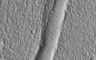 <h1>PIA07858:  Fractured Ground</h1><div class="PIA07858" lang="en" style="width:601px;text-align:left;margin:auto;background-color:#000;padding:10px;max-height:150px;overflow:auto;"><p>20 April 2005 <br />This Mars Global Surveyor (MGS) Mars Orbiter Camera (MOC) image shows a wind ripple-filled trough, a fracture in a rugged and pitted plain, located northwest of Kasei Valles in the Nilus Chaos region.</p><p>Location near: 26.3°N, 78.8°W <br />Image width: ~3 km (~1.9 mi) <br />Illumination from: lower left <br />Season: Northern Summer <br /></p><br /><br /><a href="http://photojournal.jpl.nasa.gov/catalog/PIA07858" onclick="window.open(this.href); return false;" title="Voir l'image 	 PIA07858:  Fractured Ground	  sur le site de la NASA">Voir l'image 	 PIA07858:  Fractured Ground	  sur le site de la NASA.</a></div>