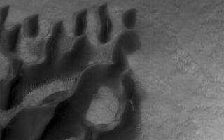 <h1>PIA08008:  Noachis Dunes</h1><div class="PIA08008" lang="en" style="width:738px;text-align:left;margin:auto;background-color:#000;padding:10px;max-height:150px;overflow:auto;"><p>22 March 2006<br />This Mars Global Surveyor (MGS) Mars Orbiter Camera (MOC) image shows dark sand dunes and relatively small, light-toned, windblown ripples on the floor of a crater in central Noachis Terra.</p><p>Location near: 50.0°S, 353.7°W <br />Image width: ~3 km (~1.9 mi) <br />Illumination from: upper left <br />Season: Southern Autumn </p><br /><br /><a href="http://photojournal.jpl.nasa.gov/catalog/PIA08008" onclick="window.open(this.href); return false;" title="Voir l'image 	 PIA08008:  Noachis Dunes	  sur le site de la NASA">Voir l'image 	 PIA08008:  Noachis Dunes	  sur le site de la NASA.</a></div>