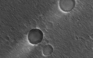 <h1>PIA08028:  Craters and Streaks</h1><div class="PIA08028" lang="en" style="width:800px;text-align:left;margin:auto;background-color:#000;padding:10px;max-height:150px;overflow:auto;"><p>1 April 2006<br />This Mars Global Surveyor (MGS) Mars Orbiter Camera (MOC) image shows two impact craters of nearly equal size, plus their associated wind streaks. These occur in far eastern Chryse Planitia. The wind streaks point toward the southwest (lower left), indicating that the responsible winds blew from the northeast. One of the two craters is shallower than the other, and has a suite of large, windblown ripples on its floor. The shallower crater with the ripples is probably older than the other, deeper crater.</p><p>Location near: 20.6°N, 30.1°W <br />Image width: ~3 km (~1.9 mi) <br />Illumination from: lower left <br />Season: Northern Winter </p><br /><br /><a href="http://photojournal.jpl.nasa.gov/catalog/PIA08028" onclick="window.open(this.href); return false;" title="Voir l'image 	 PIA08028:  Craters and Streaks	  sur le site de la NASA">Voir l'image 	 PIA08028:  Craters and Streaks	  sur le site de la NASA.</a></div>
