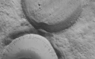 <h1>PIA08457:  Filled Craters</h1><div class="PIA08457" lang="en" style="width:477px;text-align:left;margin:auto;background-color:#000;padding:10px;max-height:150px;overflow:auto;"><p>11 May 2006<br />This Mars Global Surveyor (MGS) Mars Orbiter Camera (MOC) image shows adjacent impact craters located north-northwest of the Acheron Fossae region of Mars. The two craters are of similar size and formed by meteor impacts. However, one is much more filled than the other, indicating that it is older. The surface of the material in the older, partially-filled crater has a texture similar to the crater's surroundings. The southern (bottom) crater is bowl-shaped and is also partially-filled, however, the filling material seems to be limited to the southern half of the crater.</p><p>Location near: 44.6°N, 128.4°W <br />Image width: ~3 km (~1.9 mi) <br />Illumination from: lower left <br />Season: Northern Winter </p><br /><br /><a href="http://photojournal.jpl.nasa.gov/catalog/PIA08457" onclick="window.open(this.href); return false;" title="Voir l'image 	 PIA08457:  Filled Craters	  sur le site de la NASA">Voir l'image 	 PIA08457:  Filled Craters	  sur le site de la NASA.</a></div>