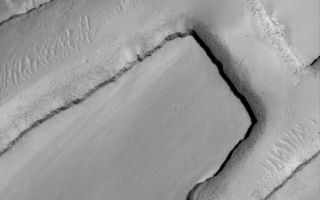 <h1>PIA08524:  Intersection</h1><div class="PIA08524" lang="en" style="width:518px;text-align:left;margin:auto;background-color:#000;padding:10px;max-height:150px;overflow:auto;"><p>9 June 2006<br />This Mars Global Surveyor (MGS) Mars Orbiter Camera (MOC) image shows a small portion of a dust-covered plain directly north of Labyrinthus Noctis which is cut by three linear troughs. The two long troughs running diagonally from the lower left (southwest) to the upper right (northeast) are connected by a third, shorter trough. Boulders derived from erosion of layered rock in the trough walls are seen perched on the sloping sidewalls and resting on the trough floors among giant windblown ripples.</p><p>Location near: 0.2°N, 105.0°W <br />Image width: ~3 km (~1.9 mi) <br />Illumination from: upper left <br />Season: Northern Spring </p><br /><br /><a href="http://photojournal.jpl.nasa.gov/catalog/PIA08524" onclick="window.open(this.href); return false;" title="Voir l'image 	 PIA08524:  Intersection	  sur le site de la NASA">Voir l'image 	 PIA08524:  Intersection	  sur le site de la NASA.</a></div>