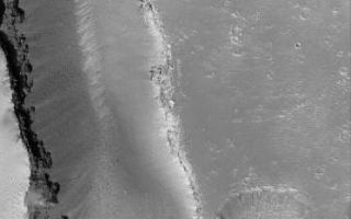 <h1>PIA08561:  Cracked Mars</h1><div class="PIA08561" lang="en" style="width:373px;text-align:left;margin:auto;background-color:#000;padding:10px;max-height:150px;overflow:auto;"><p>25 June 2006<br />This Mars Global Surveyor (MGS) Mars Orbiter Camera (MOC) image shows v-shaped troughs in the Hephaestus Fossae region of Mars. Light-toned, windblown ripples reside in the very lowest parts of the troughs, as well as on the cratered upland outside the troughs. Boulders and other types of debris, which were derived from the layered rock exposed near the top of the troughs, are seen resting on the trough floors and perched on the sloping trough walls.</p><p>Location near: 21.1°N, 236.7°W <br />Image width: ~3 km (~1.9 mi) <br />Illumination from: lower left <br /> Season: Northern Spring </p><br /><br /><a href="http://photojournal.jpl.nasa.gov/catalog/PIA08561" onclick="window.open(this.href); return false;" title="Voir l'image 	 PIA08561:  Cracked Mars	  sur le site de la NASA">Voir l'image 	 PIA08561:  Cracked Mars	  sur le site de la NASA.</a></div>