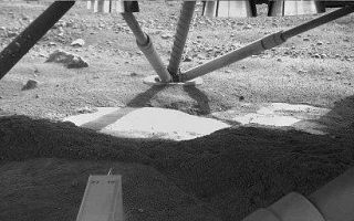 <h1>PIA10741:  Hard Substrate, Possibly Ice, Uncovered Under the Mars Lander</h1><div class="PIA10741" lang="en" style="width:512px;text-align:left;margin:auto;background-color:#000;padding:10px;max-height:150px;overflow:auto;"><p>The Robotic Arm Camera on NASA's Phoenix Mars Lander captured this image underneath the lander on the fifth Martian day, or sol, of the mission. Descent thrusters on the bottom of the lander are visible at the top of the image.</p><p>This view from the north side of the lander toward the southern leg shows smooth surfaces cleared from overlying soil by the rocket exhaust during landing. One exposed edge of the underlying material was seen in Sol 4 images, but the newer image reveals a greater extent of it. The abundance of excavated smooth and level surfaces adds evidence to a hypothesis that the underlying material is an ice table covered by a thin blanket of soil.</p><p>The bright-looking surface material in the center, where the image is partly overexposed, may not be inherently brighter than the foreground material in shadow.</p><p>The Phoenix Mission is led by the University of Arizona, Tucson, on behalf of NASA. Project management of the mission is by NASA's Jet Propulsion Laboratory, Pasadena, Calif. Spacecraft development is by Lockheed Martin Space Systems, Denver.<br /><br /><a href="http://photojournal.jpl.nasa.gov/catalog/PIA10741" onclick="window.open(this.href); return false;" title="Voir l'image 	 PIA10741:  Hard Substrate, Possibly Ice, Uncovered Under the Mars Lander	  sur le site de la NASA">Voir l'image 	 PIA10741:  Hard Substrate, Possibly Ice, Uncovered Under the Mars Lander	  sur le site de la NASA.</a></div>