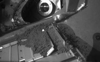 <h1>PIA10782:  Small Effect of Vibrating Martian Soil Sample on Oven Door</h1><div class="PIA10782" lang="en" style="width:512px;text-align:left;margin:auto;background-color:#000;padding:10px;max-height:150px;overflow:auto;"><p>In both images of this before-and-after sequence, a sample of Martian soil rests on a screen over the opening to one of the eight ovens of the Thermal and Evolved-Gas Analyzer instrument (TEGA) on NASA's Phoenix Mars Lander. Between the times at which the lander's Robotic Arm Camera took these images during the mission's 14th Martian day after landing (June 8, 2008), TEGA vibrated the screen for about seven minutes.</p><p>The TEGA oven doors are on a surface sloping at about 45 degrees, with the top of the doors near the lower edge of these images. The downhill direction on this part of the instrument appears upwards in the image. The screen-covered opening for the oven intended to analyze this soil sample is between the vertically positioned door at the right end of the series of doors and the partially opened door to the left of that one. The screen is covered with soil in this pair of images, but visible in a view from about the same angle taken before the soil was delivered, at <a href="/catalog/PIA10769" class="external free" target="wpext">PIA10769</a>. For scale, the doors are about 10 centimeters (4 inches) long.</p><p>The "before" image here is the one in which the circular feature near the top of the image is more brightly lit. In the image taken after about seven minutes of shaking, the soil resting on the screen has slumped almost imperceptibly downhill. A dark gap about 3 millimeters (one-tenth of an inch) wide opened at the top edge of the screen. </p><p>The Phoenix Mission is led by the University of Arizona, Tucson, on behalf of NASA. Project management of the mission is by NASA's Jet Propulsion Laboratory, Pasadena, Calif. Spacecraft development is by Lockheed Martin Space Systems, Denver.<br /><br /><a href="http://photojournal.jpl.nasa.gov/catalog/PIA10782" onclick="window.open(this.href); return false;" title="Voir l'image 	 PIA10782:  Small Effect of Vibrating Martian Soil Sample on Oven Door	  sur le site de la NASA">Voir l'image 	 PIA10782:  Small Effect of Vibrating Martian Soil Sample on Oven Door	  sur le site de la NASA.</a></div>