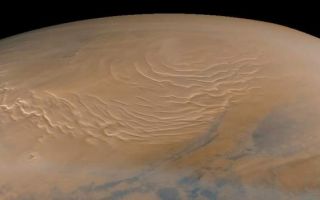<h1>PIA01471:  Martian North Polar Cap on September 12, 1998 (color)</h1><div class="PIA01471" lang="en" style="width:800px;text-align:left;margin:auto;background-color:#000;padding:10px;max-height:150px;overflow:auto;"><p>Mars Global Surveyor's Mars Orbiter Camera obtained its last SPO-2 images of Mars on September 12, 1998. SPO-2, or "Science Phasing Orbit-2," took place between early June and mid-September 1998. Shown above are MOC wide angle (red and blue band) images of the martian north polar region obtained around 3:15 a.m. PDT on September 12, 1998. This color composite was made using red and blue wide angle MOC images 55001 and 55002--these were the last pictures taken of the planet until the camera resumes its work in late-March 1999.<p>The north polar layered deposits, a terrain believed composed of ice and dust deposited over millions of years, dominates this view. The swirled pattern in the images above are channels eroded into this deposit. The pattern is accentuated by the illumination and seasonal frost differences that arise on sun-facing slopes during the summer. The permanent portion of the north polar cap covers most of the region with a layer of ice of unknown thickness.<p>At the time this picture was obtained, the martian northern hemisphere was in the midst of the early Spring season. The margin of the seasonal carbon dioxide frost cap was at about 67° N, so the ground throughout this image is covered by frost. The frost appears pink rather than white; this may result from textural changes in the frost as it sublimes or because the frost is contaminated by a small amount of reddish martian dust. Please note that these pictures have not been "calibrated" and so the colors are not necessarily accurately portrayed.<p>In addition to the north polar cap, the pictures also show some clouds (bluish-white wisps). Some of the clouds on the right side of the images are long, linear features that cast similar long, dark shadows on the ground beneath them.<p>When the MOC resumes imaging of Mars in March 1999, summer will have arrived in the north polar regions and the area surrounding the permanent polar cap will appear much darker than it does here. The dark features surrounding the cap are sand dunes, and these are expected to darken over the next several months as seasonal ice sublimes and is removed from the surface.<p><p>Malin Space Science Systems and the California Institute of Technology built the MOC using spare hardware from the Mars Observer mission. MSSS operates the camera from its facilities in San Diego, CA. The Jet Propulsion Laboratory's Mars Surveyor Operations Project operates the Mars Global Surveyor spacecraft with its industrial partner, Lockheed Martin Astronautics, from facilities in Pasadena, CA and Denver, CO.<br /><br /><a href="http://photojournal.jpl.nasa.gov/catalog/PIA01471" onclick="window.open(this.href); return false;" title="Voir l'image 	 PIA01471:  Martian North Polar Cap on September 12, 1998 (color)	  sur le site de la NASA">Voir l'image 	 PIA01471:  Martian North Polar Cap on September 12, 1998 (color)	  sur le site de la NASA.</a></div>
