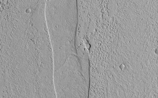 <h1>PIA04798:  Streamlined Island</h1><div class="PIA04798" lang="en" style="width:601px;text-align:left;margin:auto;background-color:#000;padding:10px;max-height:150px;overflow:auto;">MGS MOC Release No. MOC2-514, 15 October 2003<p />This Mars Global Surveyor (MGS) Mars Orbiter Camera (MOC) picture shows a streamlined island in Marte Vallis, a large outflow channel system that crosses the 180°W meridian between the Elysium and Amazonis regions of Mars. The flow patterns on the floor of Marte Vallis might be the remains of lava flows or mud flows. Marte is the Spanish word for Mars. Most of the largest valleys on the red planet are named for "Mars" in various languages. This island is located near 21.8°N, 175.3°W. The picture covers an area 3 km (1.9 mi) wide and is illuminated by sunlight from the lower left.<br /><br /><a href="http://photojournal.jpl.nasa.gov/catalog/PIA04798" onclick="window.open(this.href); return false;" title="Voir l'image 	 PIA04798:  Streamlined Island	  sur le site de la NASA">Voir l'image 	 PIA04798:  Streamlined Island	  sur le site de la NASA.</a></div>