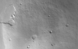 <h1>PIA04813:  Hecates Tholus</h1><div class="PIA04813" lang="en" style="width:688px;text-align:left;margin:auto;background-color:#000;padding:10px;max-height:150px;overflow:auto;">MGS MOC Release No. MOC2-526, 27 October 2003<p />This Mars Global Surveyor (MGS) Mars Orbiter Camera (MOC) red wide angle image shows Hecates Tholus, the northernmost of the three large Elysium volcanoes. The non-circular pit just southwest (toward lower left) of the center of this view is the summit caldera, a complex depression formed by collapse. This volcano has several large impact craters on its surface, indicating that it is a relatively old landform. None of the martian volcanoes are thought to be active today, and none of the MOC images of the martian volcanoes obtained thus far give any indication to the contrary. Hecates Tholus is located at 32°N, 210°W. This picture is illuminated by sunlight from the lower left and covers an area about 170 km (~105 mi) across.<br /><br /><a href="http://photojournal.jpl.nasa.gov/catalog/PIA04813" onclick="window.open(this.href); return false;" title="Voir l'image 	 PIA04813:  Hecates Tholus	  sur le site de la NASA">Voir l'image 	 PIA04813:  Hecates Tholus	  sur le site de la NASA.</a></div>