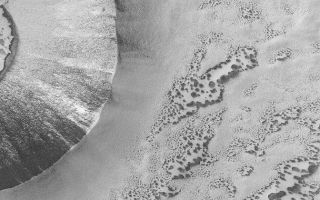 <h1>PIA04841:  Defrosting Scene</h1><div class="PIA04841" lang="en" style="width:672px;text-align:left;margin:auto;background-color:#000;padding:10px;max-height:150px;overflow:auto;">MGS MOC Release No. MOC2-531, 1 November 2003<p />This June 2003 Mars Global Surveyor (MGS) Mars Orbiter Camera (MOC) picture shows patterns created by subliming carbon dioxide frost in the south polar region of Mars. The circular feature on the west (left) side of the image is a meteor impact crater; its center is just out of view. The dark, spotted features at the bottom and right are patches of windblown sand that have been covered with frost. In this springtime image, the frost has been subliming away for several months. As frost is removed from the patches of sand, it creates a pattern of dark spots. This picture is located near 66.1°S, 322.6°W. The image is illuminated by sunlight from the upper left and covers an area 3 km (1.9 mi) wide.<br /><br /><a href="http://photojournal.jpl.nasa.gov/catalog/PIA04841" onclick="window.open(this.href); return false;" title="Voir l'image 	 PIA04841:  Defrosting Scene	  sur le site de la NASA">Voir l'image 	 PIA04841:  Defrosting Scene	  sur le site de la NASA.</a></div>