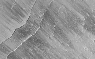 <h1>PIA04843:  Tharsis Wind Streaks</h1><div class="PIA04843" lang="en" style="width:800px;text-align:left;margin:auto;background-color:#000;padding:10px;max-height:150px;overflow:auto;">MGS MOC Release No. MOC2-533, 3 November 2003<p />This Mars Global Surveyor (MGS) Mars Orbiter Camera (MOC) picture shows dark wind streaks on a plain east of Olympus Mons in the Tharsis region of Mars. Streaks such as these change from time to time over the course of a martian year, suggesting that they are the result of wind movement of a thin layer of bright dust. In other words, wind is not moving dark material to make the dark streaks, it is removing bright material (thin coatings of dust). This picture is located near 16.3°N, 127.7°W. The image covers an area 3 km (1.9 mi) across and is illuminated by sunlight from the upper left.<br /><br /><a href="http://photojournal.jpl.nasa.gov/catalog/PIA04843" onclick="window.open(this.href); return false;" title="Voir l'image 	 PIA04843:  Tharsis Wind Streaks	  sur le site de la NASA">Voir l'image 	 PIA04843:  Tharsis Wind Streaks	  sur le site de la NASA.</a></div>