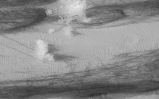 <h1>PIA04876:  Galle Crater Scene</h1><div class="PIA04876" lang="en" style="width:800px;text-align:left;margin:auto;background-color:#000;padding:10px;max-height:150px;overflow:auto;">MGS MOC Release No. MOC2-547, 17 November 2003<p />This November 2003 Mars Global Surveyor (MGS) Mars Orbiter Camera (MOC) picture shows gullies, sand dunes, and streaks formed by dust devils in southern Galle Crater. The gullies are seen in the upper left (northwest) corner; they originate at layered rock exposures on a hillslope, and meander downslope through a deposit of dark, windblown sand. The gullies might have formed by running water. All of the darker surfaces in this image are dunes; these dunes were covered with bright dust during the previous winter (it is now summer in the southern hemisphere of Mars). Dust devils have been darkening the dunes by removing or disrupting the coating of dust, leaving behind a chaotic plethora of darks streaks. The image is located near 51.9°S, 31.4°W. The area shown is about 3 km (1.9 mi) wide by 6.8 km (4.2 mi) high. Sunlight illuminates the scene from the upper left.<br /><br /><a href="http://photojournal.jpl.nasa.gov/catalog/PIA04876" onclick="window.open(this.href); return false;" title="Voir l'image 	 PIA04876:  Galle Crater Scene	  sur le site de la NASA">Voir l'image 	 PIA04876:  Galle Crater Scene	  sur le site de la NASA.</a></div>