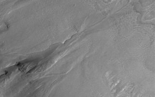 <h1>PIA04888:  Multiple-Event Gully</h1><div class="PIA04888" lang="en" style="width:800px;text-align:left;margin:auto;background-color:#000;padding:10px;max-height:150px;overflow:auto;">MGS MOC Release No. MOC2-554, 24 November 2003<p />Middle- and polar-latitude gullies are common on crater and trough walls in the martian southern hemisphere. Some also occur in the north. One of the controversies surrounding gullies is whether they involved fluid flow (such as liquid water) or were formed by dry landsliding processes. The occurrence of banked and leveed channels in many gullies argues that they formed by fluid flow. Another question centers on whether gullies are "one-shot deals" or involved more than one episode of fluid flow. This Mars Global Surveyor (MGS) Mars Orbiter Camera (MOC) image, acquired in November 2003, shows a gully with an apron, near the center of the frame, that formed by multiple fluid flows. The apron of debris at the base of the gully near the center of the picture is not just one apron, it is three. Three separate aprons formed at three different times. First, the larger, left-most apron formed. Later, another event caused fluid to cut through that apron and create a new one (the middle of the three). Later, a third event cut both aprons and formed a small, third one. This image shows the wall of an impact crater located near 51.3°S, 326.6°W. The image covers an area 3 km (1.9 mi) wide, and is illuminated by sunlight from the upper left.<br /><br /><a href="http://photojournal.jpl.nasa.gov/catalog/PIA04888" onclick="window.open(this.href); return false;" title="Voir l'image 	 PIA04888:  Multiple-Event Gully	  sur le site de la NASA">Voir l'image 	 PIA04888:  Multiple-Event Gully	  sur le site de la NASA.</a></div>