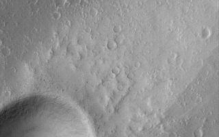 <h1>PIA04891:  Elysium Mons Wind Streak</h1><div class="PIA04891" lang="en" style="width:601px;text-align:left;margin:auto;background-color:#000;padding:10px;max-height:150px;overflow:auto;">MGS MOC Release No. MOC2-556, 26 November 2003<p />This Mars Global Surveyor (MGS) Mars Orbiter Camera (MOC) image shows a wind streak formed behind a meteor impact crater on the lower north flank of the volcano, Elysium Mons. Winds blow down the volcano slope, toward the northeast (toward upper right), causing a tail of uneroded dust to be captured behind the crater. Thin, filamentary dark streaks (resembling pencil scratches in this image) can be seen on the surface of the bright wind streak; these may have formed by disruption of surface dust by passing dust devils. This picture is located near 27.7°N, 212.7°W. The image covers an area 3 km (1.9 mi) wide, and is illuminated by sunlight from the left.<br /><br /><a href="http://photojournal.jpl.nasa.gov/catalog/PIA04891" onclick="window.open(this.href); return false;" title="Voir l'image 	 PIA04891:  Elysium Mons Wind Streak	  sur le site de la NASA">Voir l'image 	 PIA04891:  Elysium Mons Wind Streak	  sur le site de la NASA.</a></div>