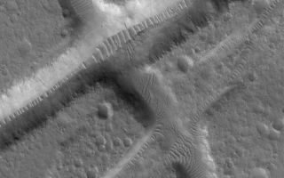 <h1>PIA04915:  Troughs in Tempe Terra</h1><div class="PIA04915" lang="en" style="width:800px;text-align:left;margin:auto;background-color:#000;padding:10px;max-height:150px;overflow:auto;">MGS MOC Release No. MOC2-570, 10 December 2003<p />This Mars Global Surveyor (MGS) Mars Orbiter Camera (MOC) image shows troughs created by movement along geologic faults in the upper crust of Mars in the Tempe Terra region. Large ripple-like dunes have formed in sediment trapped on the floors of the troughs. In most cases, the ripples are oriented with their crests perpendicular to the troughs, indicating that local winds within each trough are responsible for their patterns. This area is located near 33.1°N, 70.2°W. The image covers an area approximately 3 km (1.9 mi) wide and is illuminated from the lower left.<br /><br /><a href="http://photojournal.jpl.nasa.gov/catalog/PIA04915" onclick="window.open(this.href); return false;" title="Voir l'image 	 PIA04915:  Troughs in Tempe Terra	  sur le site de la NASA">Voir l'image 	 PIA04915:  Troughs in Tempe Terra	  sur le site de la NASA.</a></div>