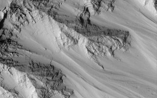 <h1>PIA04920:  Layers in Tithonium</h1><div class="PIA04920" lang="en" style="width:800px;text-align:left;margin:auto;background-color:#000;padding:10px;max-height:150px;overflow:auto;">MGS MOC Release No. MOC2-570, 10 December 2003<p />This Mars Global Surveyor (MGS) Mars Orbiter Camera (MOC) picture shows eroded layered bedrock outcrops in the upper walls of one of the depressions in the Tithonium Chasma trough system. Tithonium Chasma is one of the canyons of the Valles Marineris, a vast gouge that--if it occurred on Earth-would span the distance from Los Angeles, California, to New York City. The Valles Marineris canyons were not carved by running water, instead they formed mostly by the combined forces of faulting and mass movement (landslides) as gravity eroded materials from the walls. This image is located near 4.2°S, 85.1°W. The image covers an area approximately 3 km (1.9 mi) wide and is illuminated from the lower left.<br /><br /><a href="http://photojournal.jpl.nasa.gov/catalog/PIA04920" onclick="window.open(this.href); return false;" title="Voir l'image 	 PIA04920:  Layers in Tithonium	  sur le site de la NASA">Voir l'image 	 PIA04920:  Layers in Tithonium	  sur le site de la NASA.</a></div>