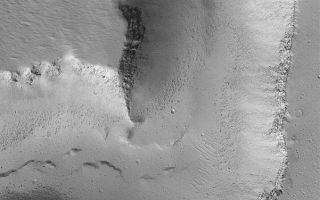 <h1>PIA05913:  Channel on Ascraeus Mons</h1><div class="PIA05913" lang="en" style="width:601px;text-align:left;margin:auto;background-color:#000;padding:10px;max-height:150px;overflow:auto;"><p>6 May 2004<br />This Mars Global Surveyor (MGS) Mars Orbiter Camera (MOC) image shows a portion of a deep channel formed on the northern flank of the large volcano, Ascraeus Mons. Layers of volcanic rock are exposed in the channel walls, and the dark dots on the valley floor are boulders derived from erosion of these materials. The picture occurs near 14.5°N, 102.8°W, and is illuminated from the lower left. The picture covers an area about 3 km (1.9 mi) across.</p><br /><br /><a href="http://photojournal.jpl.nasa.gov/catalog/PIA05913" onclick="window.open(this.href); return false;" title="Voir l'image 	 PIA05913:  Channel on Ascraeus Mons	  sur le site de la NASA">Voir l'image 	 PIA05913:  Channel on Ascraeus Mons	  sur le site de la NASA.</a></div>